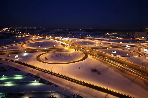 Night winter cityscape with big interchange, lighting columns an — Stock Photo, Image