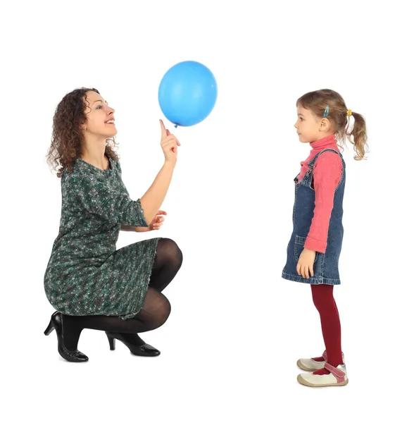 Little girl and her mother playing with blue balloon side view i — Stock Photo, Image