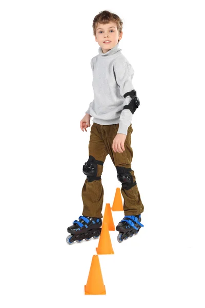 Pequeno rolo menino limpa obstáculos laranja cones olhando para camer — Fotografia de Stock