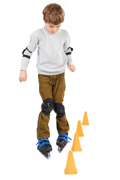Μικρό αγόρι rollerblading κοντά πορτοκαλί κώνους, κοιτάζοντας προς τα κάτω απομονωμένες — Φωτογραφία Αρχείου