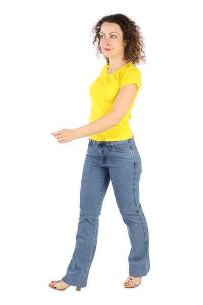 Νεαρή γυναίκα ελκυστική στο κίτρινο πουκάμισο και τζιν περπάτημα αριστερά είναι — Φωτογραφία Αρχείου