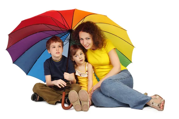 Mother, daughter and son with big multicolored umbrella sitting — Stock Photo, Image