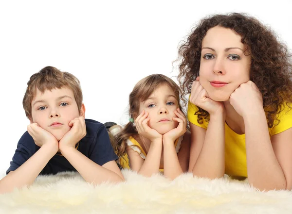 Matka s dvěma dětmi vážné leží na bílém tahem studio pro natáčení — Stock fotografie
