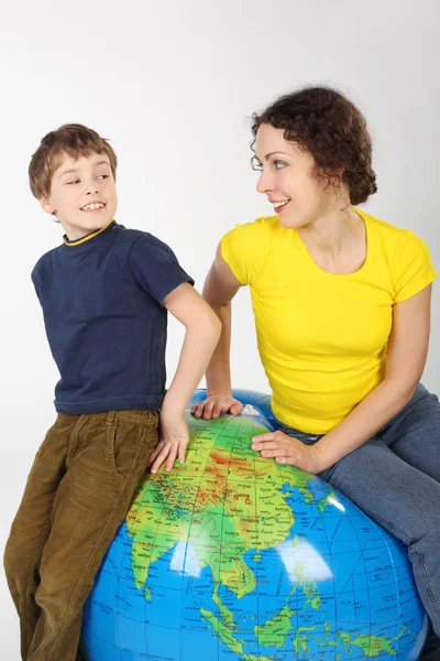 어머니와 아들이 큰 풍선 글로브, 웃 고 보기에 앉아 — 스톡 사진