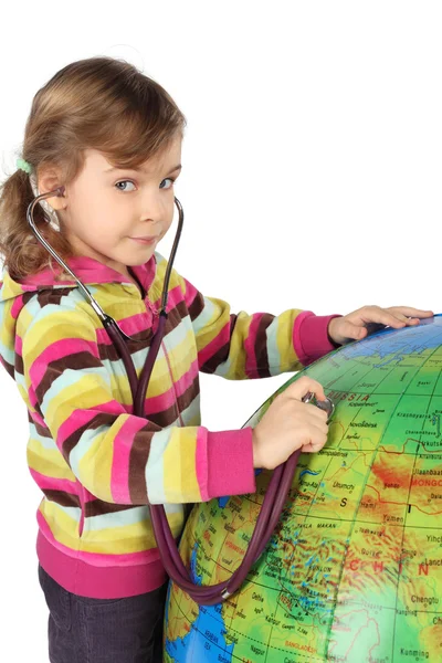 Liten flicka med stetoskop och stor uppblåsbar jordglob, söker en — Stockfoto