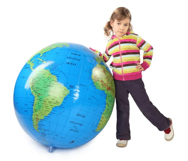 Little girl standing near big inflatable globe, thrust out one l — Stock Photo, Image