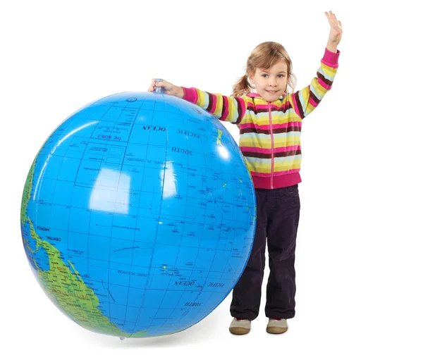 Little girl standing and holding big inflatable globe, putting o — Stock Photo, Image