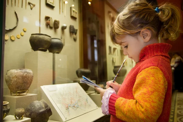Kleines Mädchen schreibt bei Exkursion in historischer Stadt an Schreibbücher — Stockfoto