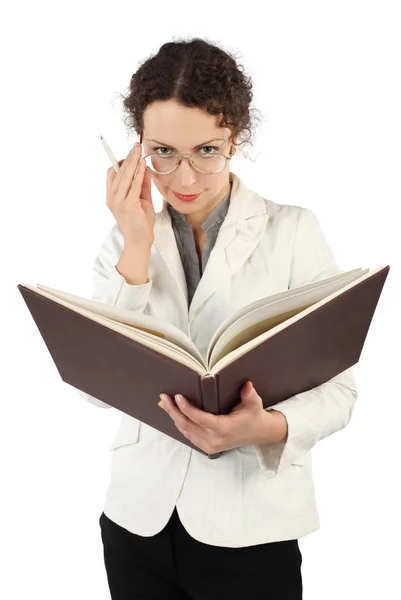 Young serious woman arranging glasses and holding big book and p — Stock Photo, Image