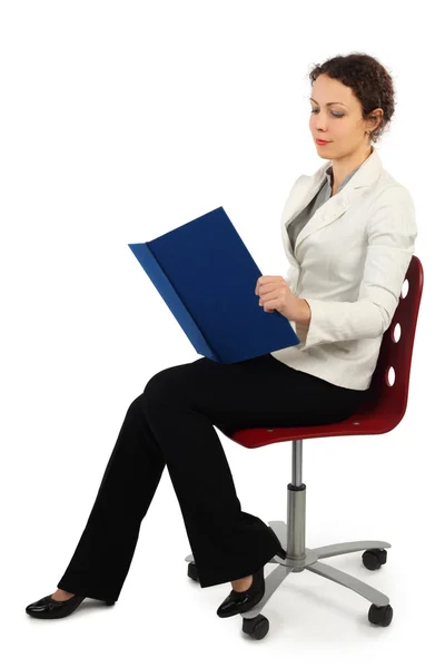 Fiatal, vonzó nő üzleti ruha ül a széken, és re — Stock Fotó