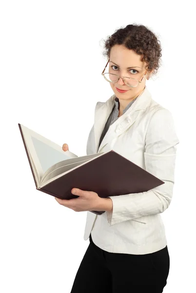 Молода серйозна жінка в окулярах тримає велику книгу, дивлячись на прийшла — стокове фото