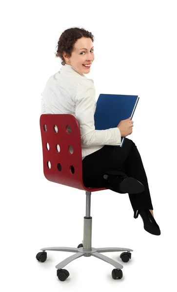 Junge attraktive Frau im Businesskleid sitzt auf Stuhl und hockt — Stockfoto
