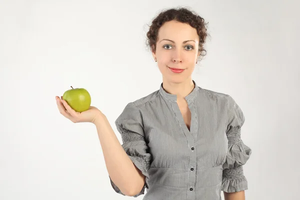 年轻有魅力的女人举行一个苹果在手中，看着 — 图库照片