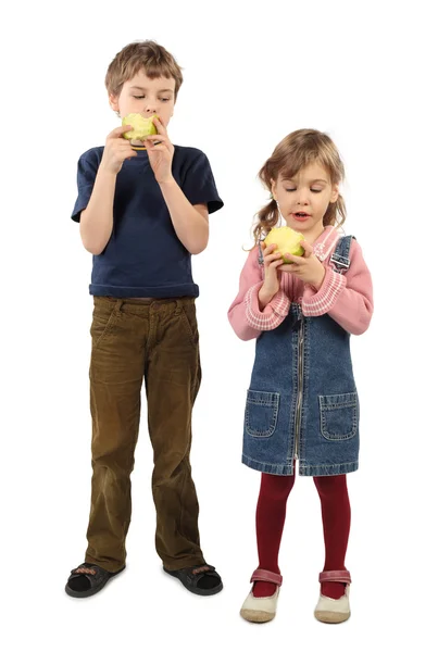 Menino e menina de pé e comendo grandes maçãs isoladas em w — Fotografia de Stock