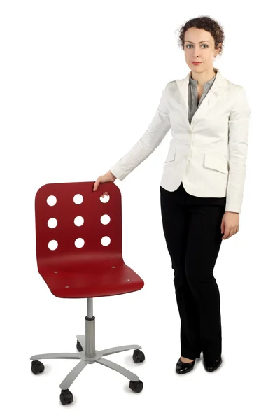 在业务中的年轻美丽女人穿衣服站在靠近红色扶手椅, — 图库照片