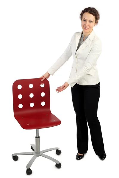 Junge Schönheit im Businesskleid steht neben rotem Sessel — Stockfoto
