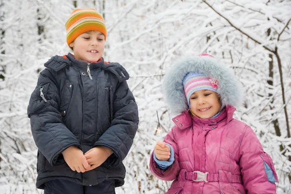 Cheerful boy and little girl with Bengal fire in hand in winter — Stock Photo, Image