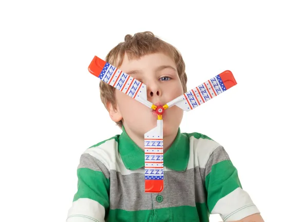 Menino em camiseta listrada com hélice de brinquedo na boca isolado em — Fotografia de Stock