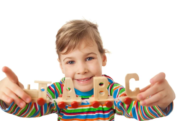 Vrij klein meisje houdt in handen speelgoed houten stoom locomotieven wi — Stockfoto