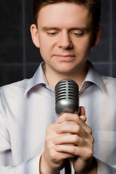 Young man in shirt keeps in hands microphone — Stock Photo, Image