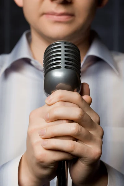 Микрофон в руках человека, фокус на пальцах — стоковое фото