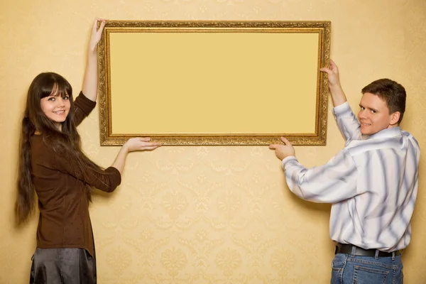 아름 다운 젊은 여자와 웃는 남자 벽 그림에 걸어 — 스톡 사진