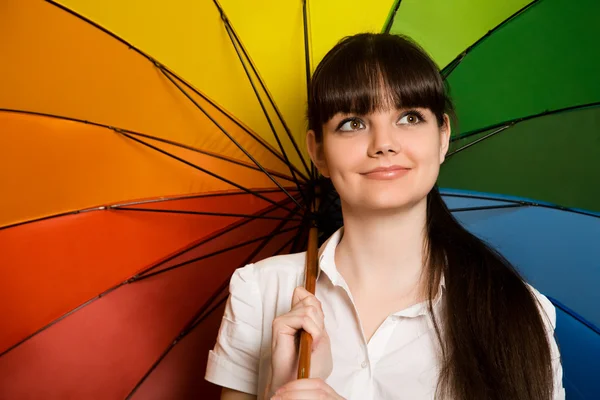 Smiling young brunette woman in white blouse with multi-coloured — Stock Photo, Image