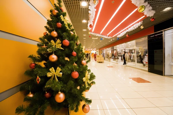 Päls-tree tätt omfattas av juldekorationer i shopping cent — Stockfoto