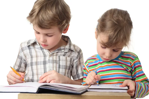 Маленький белый мальчик и девочка рисуют в блокнотах, наполовину бо — стоковое фото