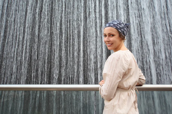 Piękna młoda kobieta w białej koszuli stojący w pobliżu duże fontanny i — Zdjęcie stockowe