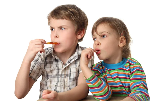 Kisfiú és a lány eszik nyalókák és látszó-on bal oldalán, h — Stock Fotó
