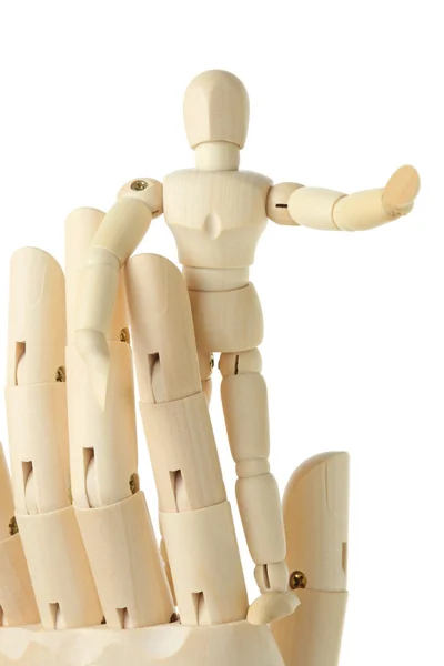 Wooden figure of little man standing on big hand and pointing at — Stock Photo, Image