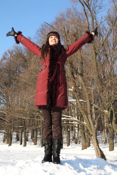 Joven chica de belleza de pie y poniendo las manos arriba, al aire libre en el invierno — Foto de Stock