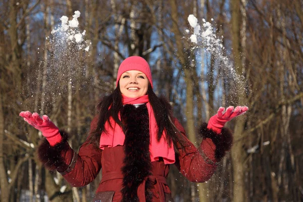 Joven chica de belleza en bufanda rosa y sombrero sonriente trepando nieve — Foto de Stock