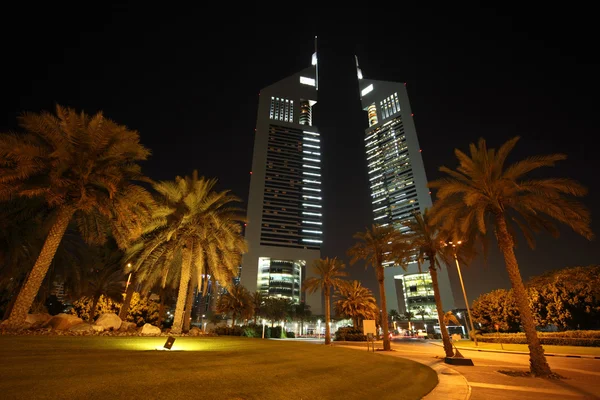 DUBAI - 18 DE ABRIL: Emirates Torres y zona con palmeras y césped — Foto de Stock