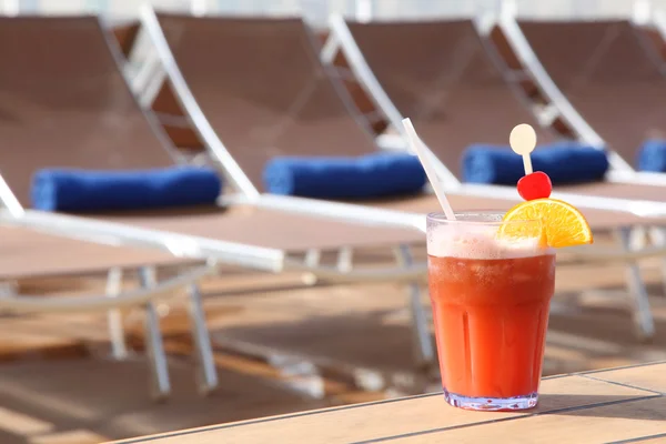 Cocktail met vruchten in glas op spoor in de buurt van strand fauteuil in cru — Stockfoto