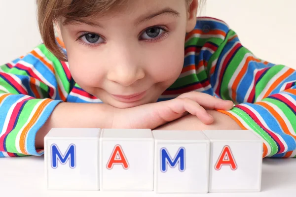 Little girl plays with cubes and puts it together in word "mothe — Stock Photo, Image