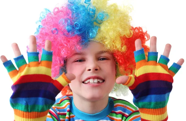 Niño con peluca de payaso y guantes multicolores sonriendo — Foto de Stock