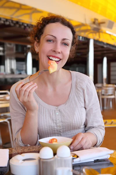 Ομορφιά μπούκλα γυναίκα σε άσπρο πουκάμισο τρώει φρούτα στην κρουαζιέρα τακτικών γραμμών r — Φωτογραφία Αρχείου