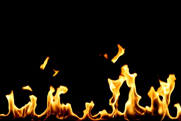 Жовтий вогонь з язиками полум'я ізольовані на чорному — стокове фото