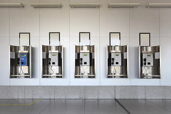 Muchos teléfonos públicos en gran salón con paredes blancas y floo de granito —  Fotos de Stock