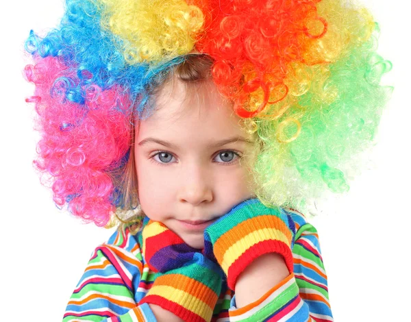 Menina em peruca de palhaço e luvas multicoloridas olhando veio — Fotografia de Stock