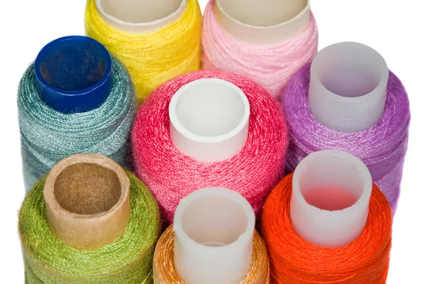 Ложки з різнокольоровими швейними нитками ізольовані на білому фоні — стокове фото