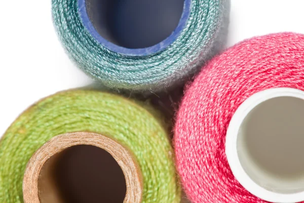 Fragment of three coils with multi-coloured sewing threads isola — Stock Photo, Image