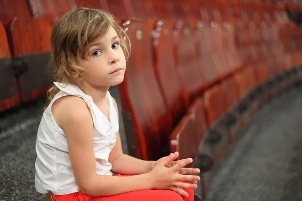 Little girl sitting on stair near armchairs in circus and lookin — Stock Photo, Image