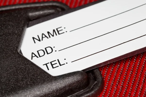 Fragment eines Etiketts mit Identifikationsdaten auf rotem Textilfabri — Stockfoto