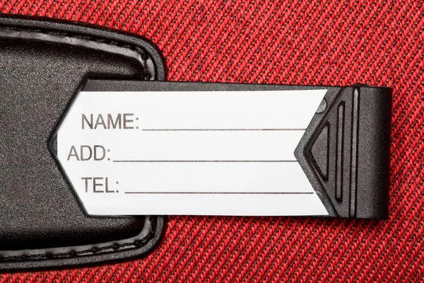 Label with identification data on red textural fabric — Stock Photo, Image