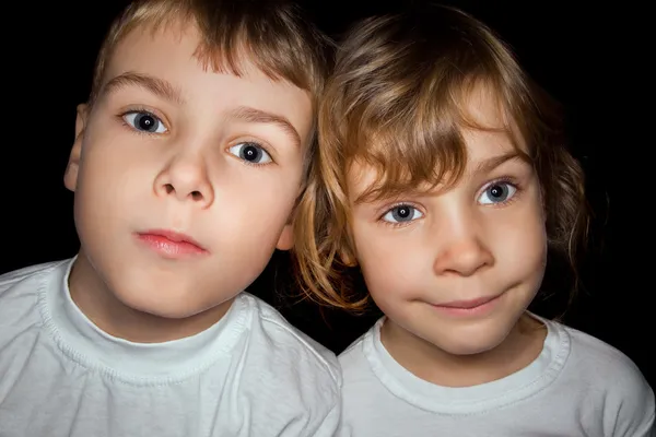 Хлопчик і дівчинка в білих футболках ізольовані на чорному фоні — стокове фото