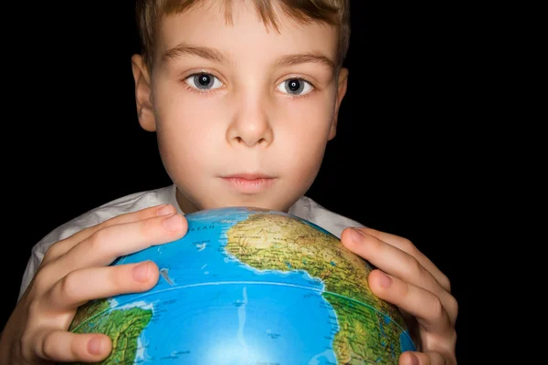 Chlapec drží v rukou nad Globus světa izolovány na černé backgro — Stock fotografie