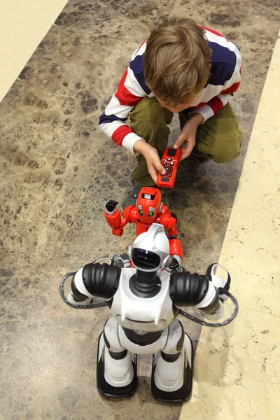 Little boy playing with two radio controlled robots view from ab — Stock Photo, Image